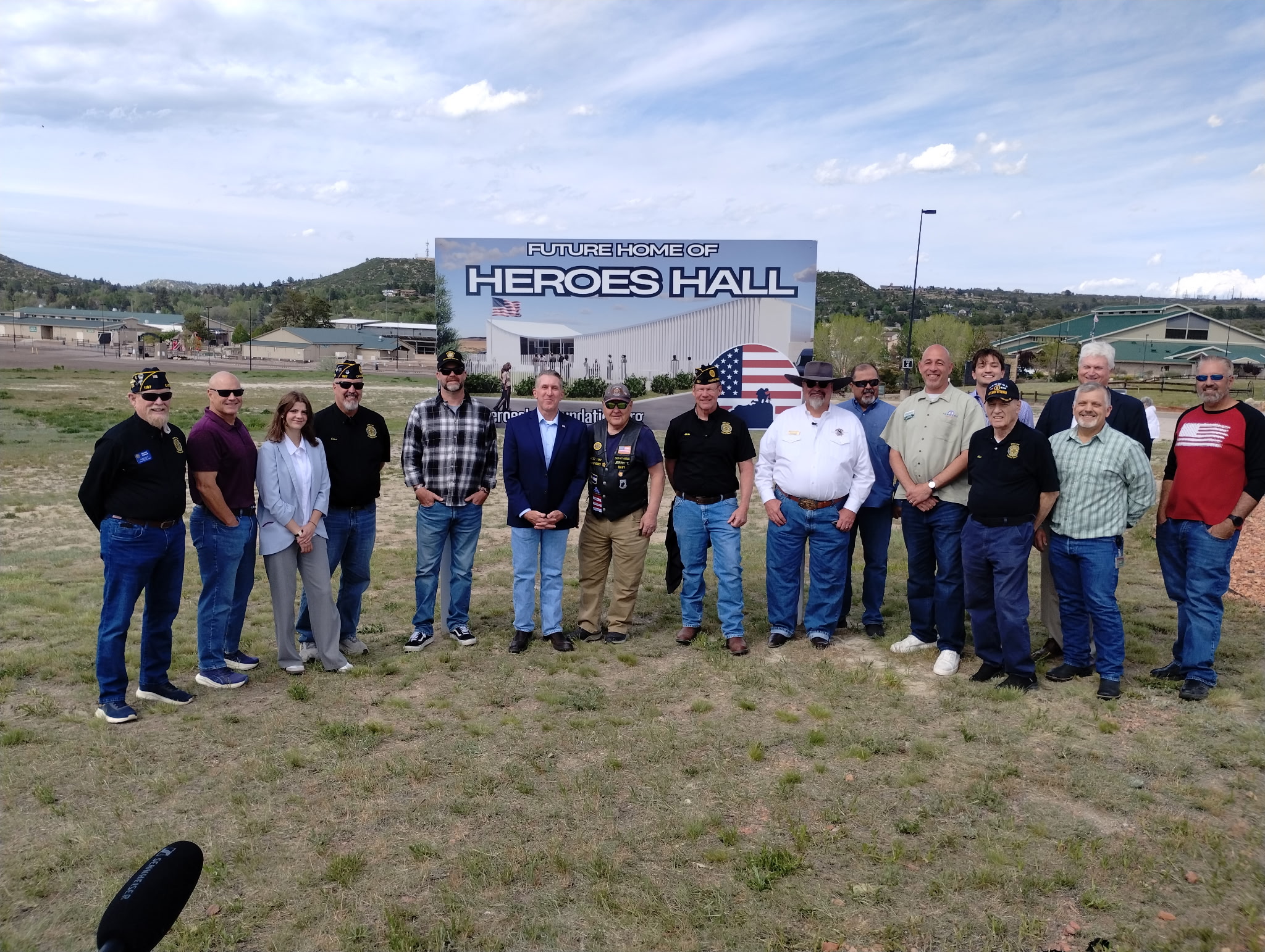 Tim Dietz with veterans from American Legion Post 1187 and the Castle Rock VFW, officials, and community members in front of the Future Home of Heroes Hall sign at the site near the Douglas County Fairgrounds